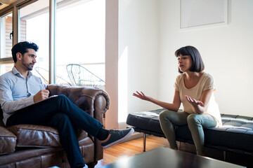 Psychologist talking with patient on therapy session.