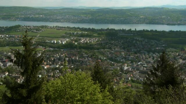 Panning Lake Zurich And The Surrounding Countryside From High Atop A Hill, With Bright Blue Sky, Clouds, Trees, And Rolling Hills Stretching To The Horizon
