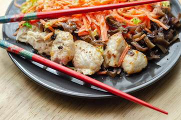 Cooked chicken breast pieces with egg noodles, carrots, and cabbage in a savory chow mein sauce