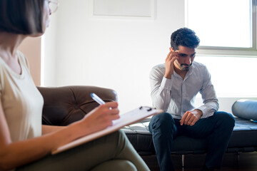 Obraz premium Psychologist taking notes during therapy session.