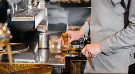 The barista prepares delicious coffee in a modern coffee shop close-up.