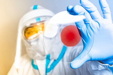 Medical health worker holding microscope slides and Covid 19 positive blood variant virus sample. Mutation Corona virus vaccine research and development concept.