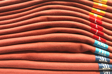 T-shirts separated by sizes are on shelves in the retail store