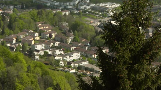 Panning The Quaint Swiss Town Of Adliswil, Outside Of Zurich, From High On A Hill With Buildings, Rooftops, And Lush Green Foliage