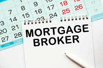 MORTGAGE BROKER. calendar and notebook with information on the desktop.