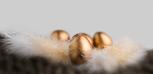 Bronze eggs on feathers. Easter background. Painted eggs.