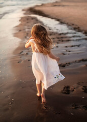 Little girl running on the beach.
