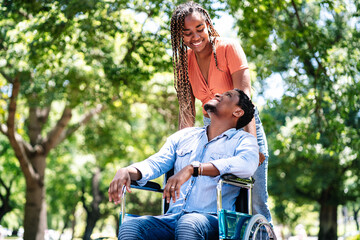 Man in a wheelchair enjoying a walk with his girlfriend.
