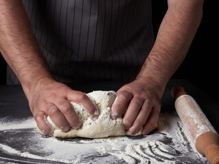 Photo of flour and men hands with flour splash. Cooking bread. Kneading the Dough.