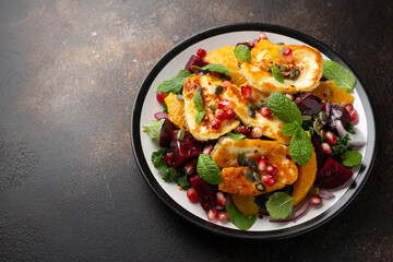 Fried Halloumi Cheese salad with beetroot, orange, pomegranate and pumpkin seeds, red onion, green vegetables. healthy food