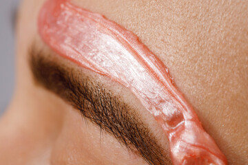 Makeup artist does facial hair removal procedure. Styling and lamination of eyebrows. Woman doing...
