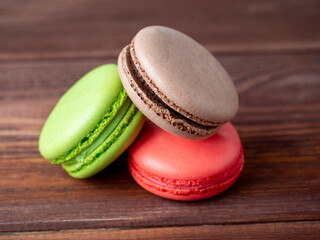 three macaroons on a wooden background. Side view. Delicious sweet dessert