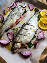 Fresh trouts and vegetables on cooking pan prepared to roast