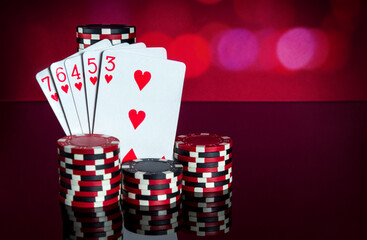 Poker cards with a straight flush combination. Close-up of playing cards and chips in poker club. Free advertising space