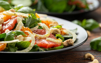 Fresh salad with fennel, orange, grapefruit, spinach and cashew nuts. healthy food.