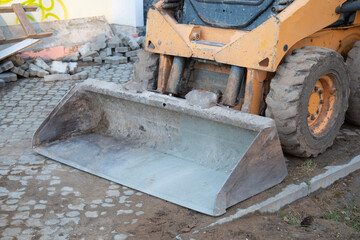 Mini tractor with bucket. Repair work with a tractor.