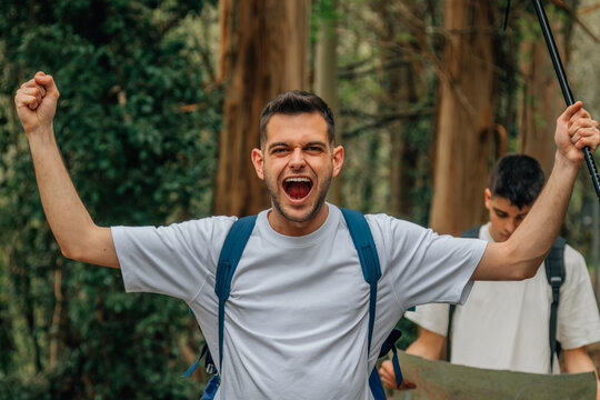 young man screaming euphoric practicing hiking or trekking excursion