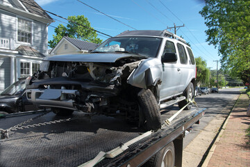 car wrecked in an accident stands on tow truck - obrazy, fototapety, plakaty