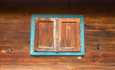 Wooden closed window with a blue frame.