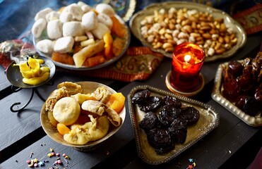 Fototapeta na wymiar Eastern sweets. Dried fruits. Nuts. Haze from an extinguished candle.