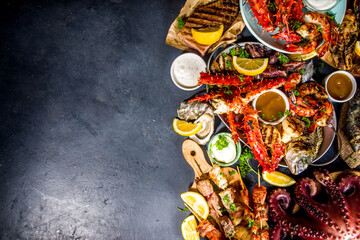 Assortment various barbecue Mediterranean grill food - fish, octopus, shrimp, crab, seafood, mussels, summer diet bbq party fest, with kebab, sauces, black concrete background, above copy space