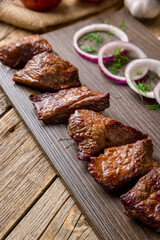 fried Kebab of veal , skewers of vial with onion and greens on old wooden table close up