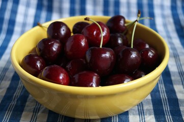 Ripe sweet cherries in a yellow bowl 