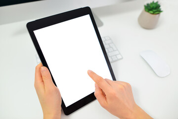 Woman hands holding tablet pc computer with isolated screen on office desk. Cropped image of young woman using digital tablet.