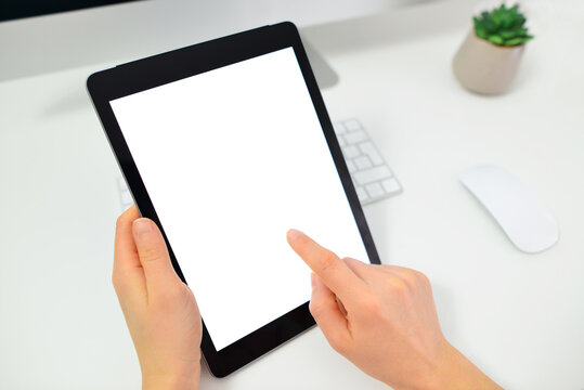 Woman hands holding tablet pc computer with isolated screen on office desk. Cropped image of young woman using digital tablet.