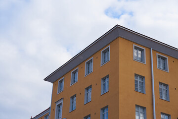 Obraz premium Orange high-rise building against the white clouds.