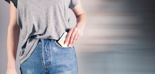girl hand putting money in jeans pocket