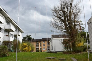 Houses with metal poles around. They suggest shape of a house that is going to be built in free space. Compulsory part of building procedure in Switzerland so that neighbors can bring objections. 