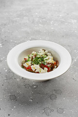 roasted red sweet peppers and Basil with feta cheese, on a light stone surface.