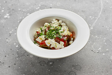 roasted red sweet peppers and Basil with feta cheese, on a light stone surface.