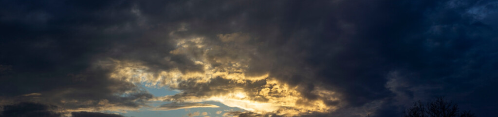 Naklejka na ściany i meble Panorama of cloudy sky with sun rays.