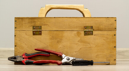 Wooden box with pruner, screwdriver and plier