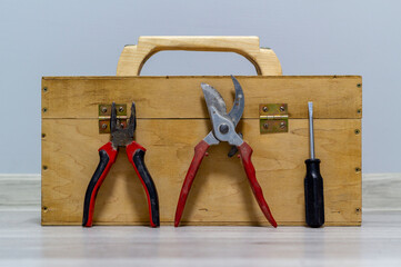 Wooden box with pruner, screwdriver and plier