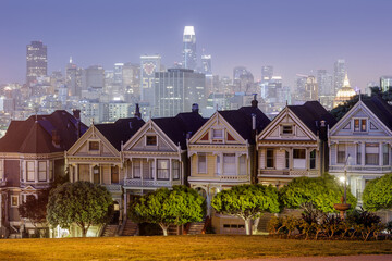 Dusk Over The Painted Ladies of San Francisco. Iconic Victorian Houses and San Francisco Skyline in...