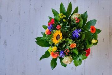 Bouquet of flowers on the wooden table. A close up of a bouquet of flowers against a wooden background with space for text and annotations