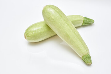 two small ripe zucchini on a white background