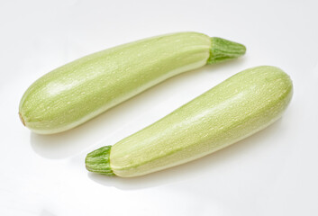 two small ripe zucchini on a white background