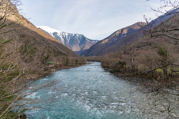 Fototapeta na wymiar Bridge over mountain river Yupshara. A cold mountain river with a rapid current in the gorge. Caucasus. Abkhazia.
