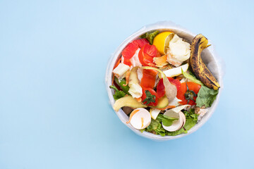 top view food leftovers in compost bin on blue background, compost, vegetable peels concept. Copy space, Sustainable and zero waste