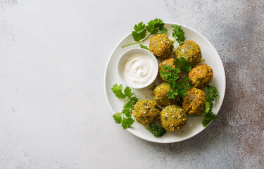 Homemade roasted falafel balls with greens and yogurt sauce