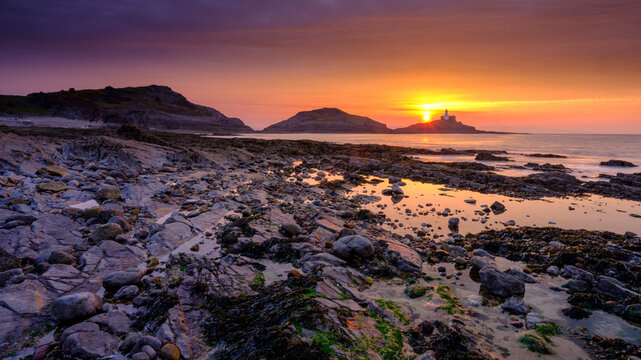 Sunrise on the Mumbles Light House from Bracelet Bay, Gower Peninsula, Wales, UK
