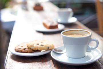 Detail of a cup of coffee and plate with biscuits