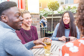 Happy multiracial friends enjoying drink together