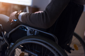 Obraz premium Young businassman in wheelchair using computer laptop at modern workplace