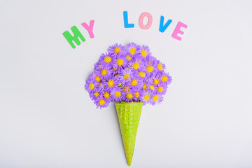 Waffle cone with flowers on white background. Flat lay, top view.