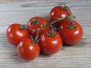 A bunch of tomatoes on a wooden table 